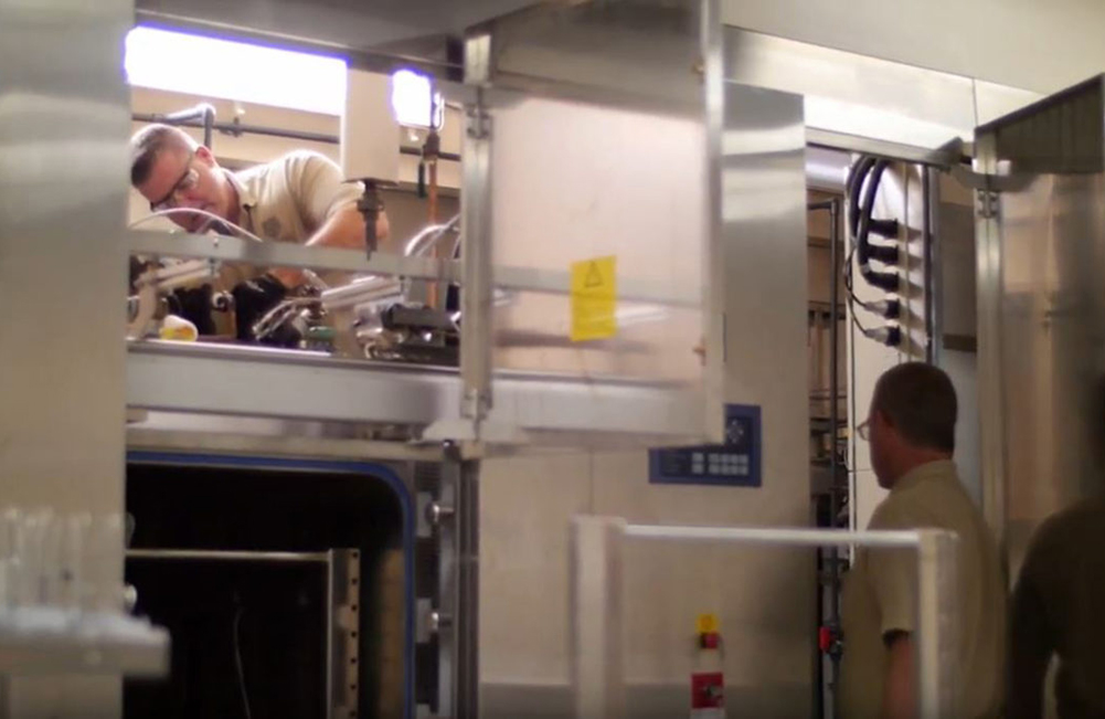 Two employees working on complex HVAC unit.