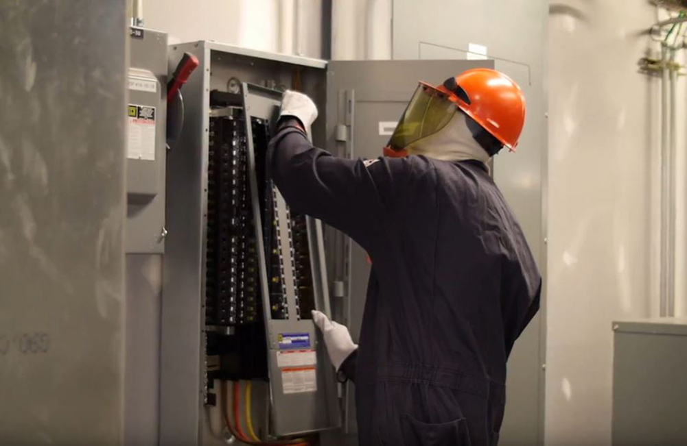 Employee installing electrical panel.