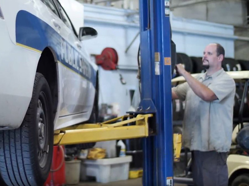 auto mechanic with car on lift