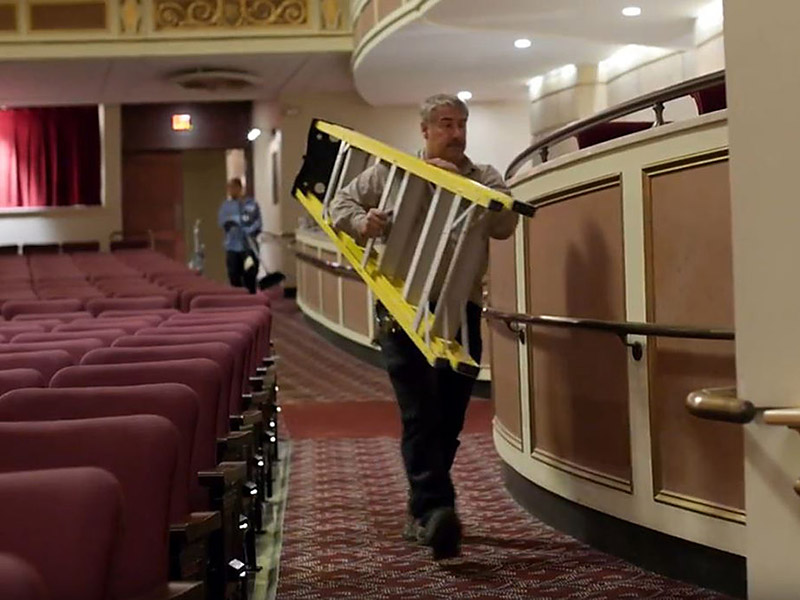worker carrying ladder through eastman theater.