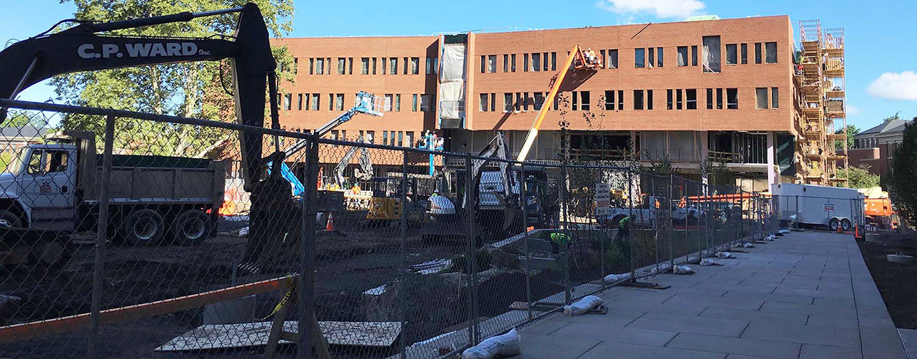 construction vehicles and fencing surrounding a building