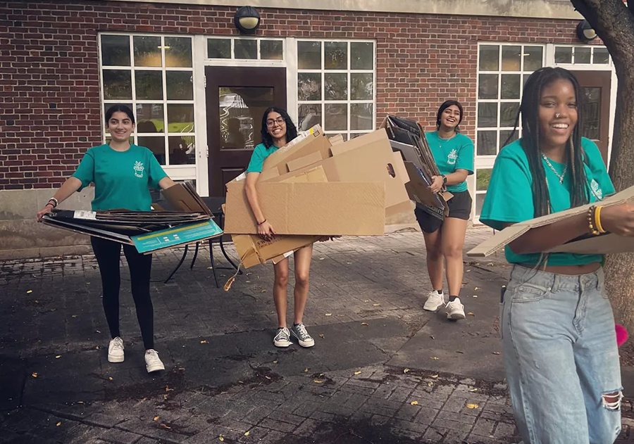 Students breaking down cardboard for recycling.